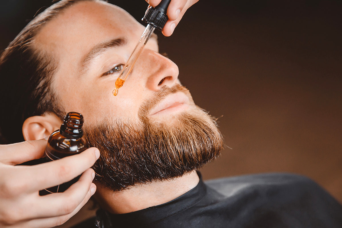 applying beard oil to the beard